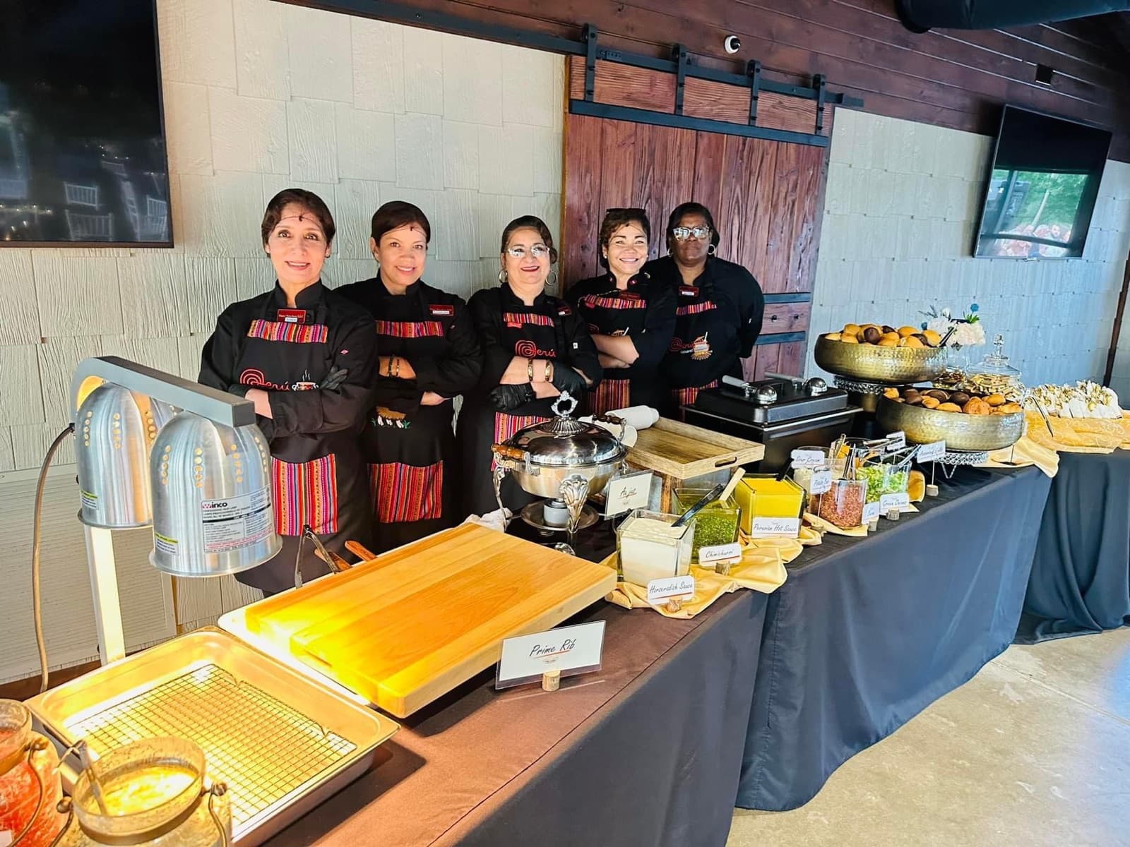 Patty's Kitchen catering team in Peruvian-trimmed aprons behind a full buffet line