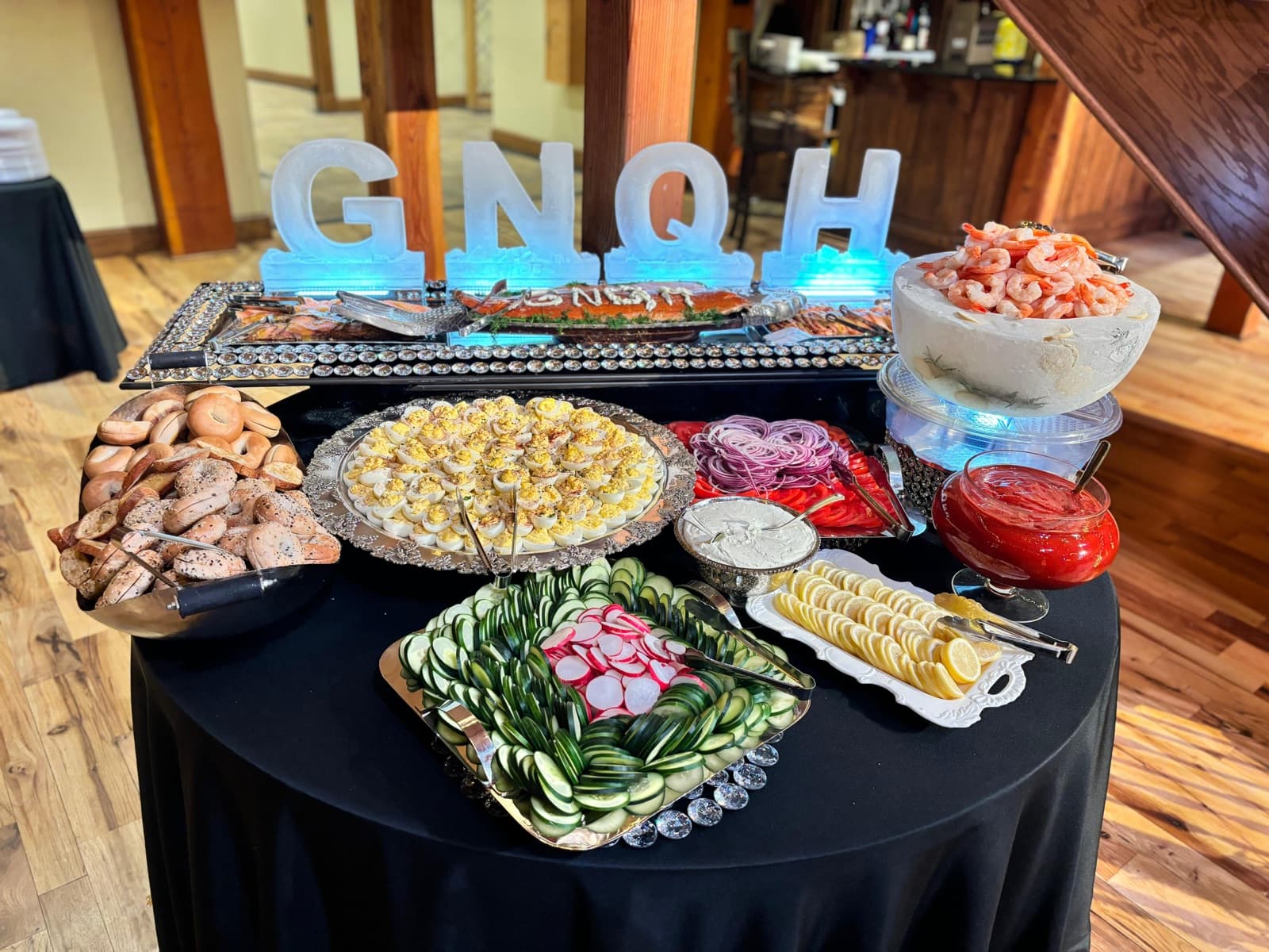 Catered event buffet with shrimp, dips, and fresh vegetable platters