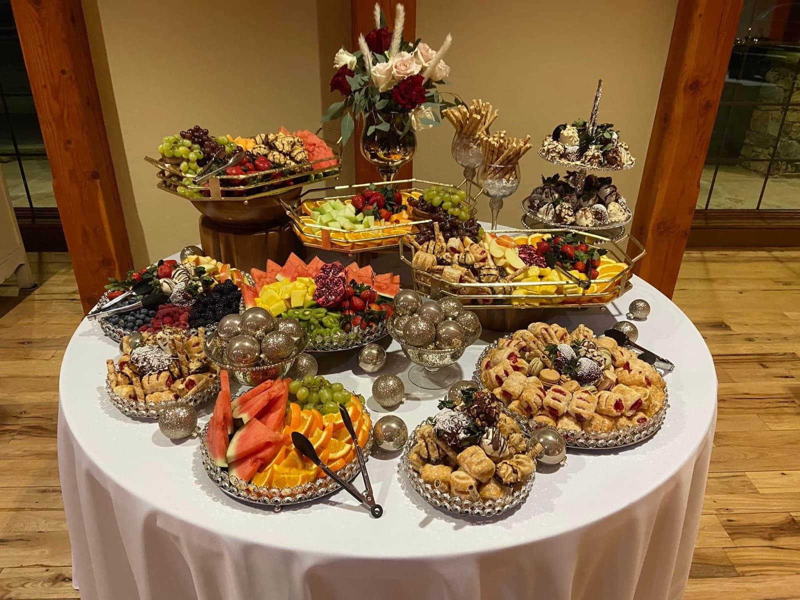 Beautifully styled catering table with fresh fruit, pastries, and desserts
